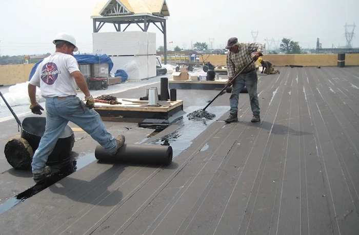 Professional roofing contractors installing a specialized low slope roofing system to ensure proper water flow and moisture protection for a commercial property.